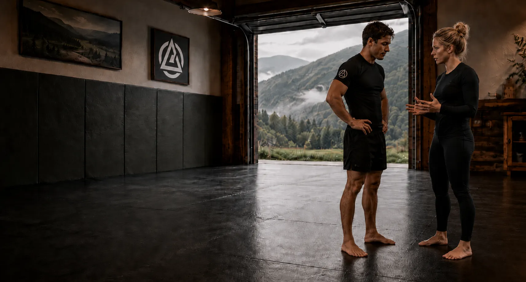 Grapplers training on mats in a private academy with mountain views.